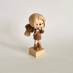 a small wooden angel figurine on a white background