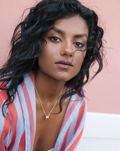 a woman with long black hair wearing a striped shirt