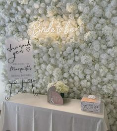 a white table topped with flowers and a sign that says bride to be on it