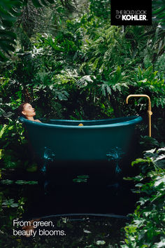 a blue bath tub sitting in the middle of a lush green forest