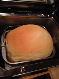 a loaf of bread sitting in an oven on top of a pan with the lid open