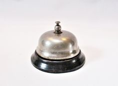 a silver bell sitting on top of a white table