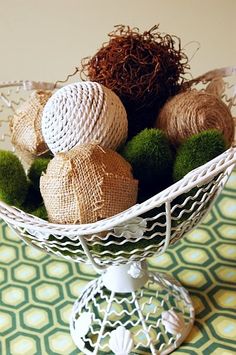 a white bowl filled with balls on top of a green and white cloth covered table