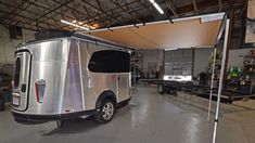 a silver trailer parked inside of a garage