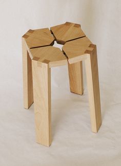 a small wooden stool with four sections cut out to look like hexagons