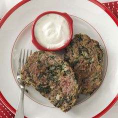 two meat patties on a plate with ranch dressing