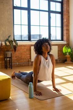 a woman is sitting on the floor doing yoga