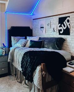 a bedroom with white brick walls and blue lights on the ceiling, along with a bed