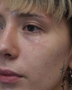 a close up of a person with piercings on their ears and nose, looking at the camera