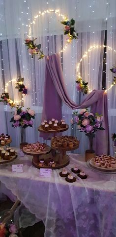 a table topped with cakes and cupcakes on top of a white table cloth