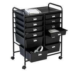 a black cart with many drawers on it and a book in the bottom drawer next to it