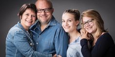 three women and one man are smiling for the camera