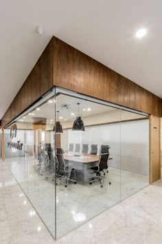 an empty conference room with glass walls and wooden accents, along with marble flooring