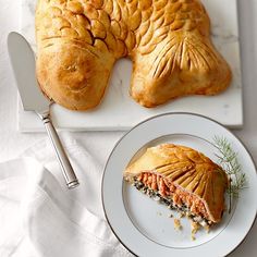 a piece of food on a plate next to a knife and fork