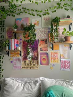 there are many plants on the wall above the bed and in the corner is a shelf with books