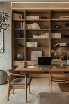 a desk with a laptop on it in front of a bookcase filled with books