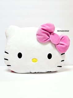 a white hello kitty pillow with a pink bow on it's head and eyes