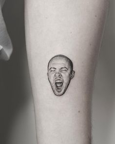 a man's face with an open mouth tattoo on the left calf sleeve,