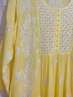 This Women's Yellow Gold Muslin Silk Handcrafted Lucknowi Chikankari A Line Kurta Long Dress is a stunning piece of art. The beautiful yellow gold color is perfect for any special occasion. The luxurious fabric and intricate embroidery make it a timeless piece that will never go out of style. 48" length Long sleeves 18" Round neck Muslin silk Chikankari embroidery Hand embroidered Dry Clean Fit: True to sizeInside Margin: NoTouch and Feel: Soft and ComfortableDispatched in 1-3 business days Festive Yellow Dress With Chikankari Embroidery, Yellow Chikankari Embroidery Traditional Wear In Chinon, Festive Yellow Kurta With Chikankari Embroidery, Yellow Lucknowi Kurta, Yellow Chikankari Embroidered Straight Kurta, Lucknowi Kurta, Phulkari Dupatta, Bridal Dupatta, Velvet Shawl