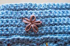 a blue crocheted object with a brown bow on it