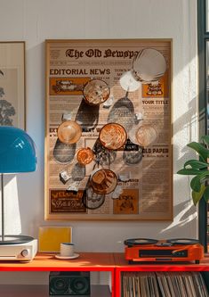 an old newspaper is on the wall next to a blue lamp and a red table