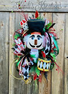 a colorful wreath on the side of a wooden fence