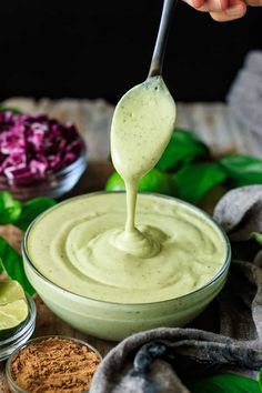 a spoon full of avocado dressing being drizzled over the top