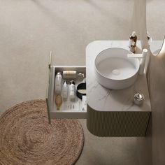 a white sink sitting on top of a bathroom counter next to a rug and mirror