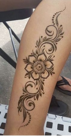 a woman's leg with a flower tattoo on it