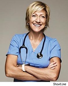 a woman in scrubs is standing with her arms crossed