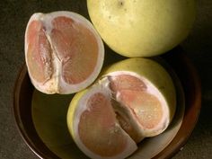 two lemons cut in half sitting on a plate with the whole fruit still attached