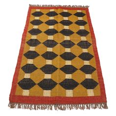 an orange, black and white rug with fringes