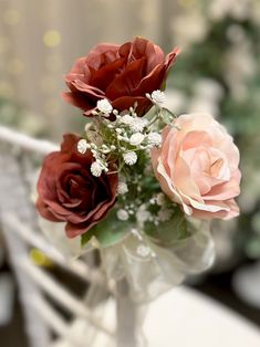 three roses in a vase sitting on a table