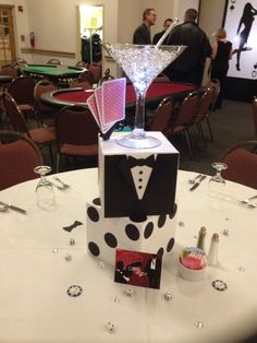 a table topped with a martini glass filled with liquid and surrounded by other tables covered in chairs