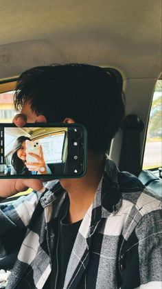 a man taking a selfie in the back seat of a car with his cell phone