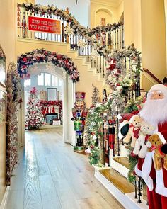 santa claus is walking down the stairs decorated with christmas garlands and teddy bear toys