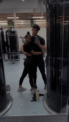 a man and woman taking a selfie in the gym