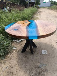 a wooden table sitting on top of a dirt road