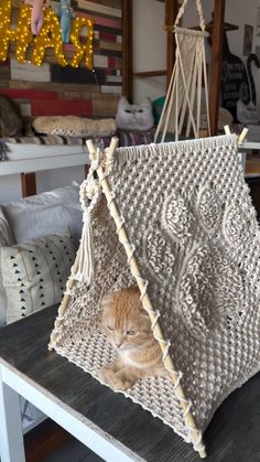 a cat laying in a hammock on top of a table