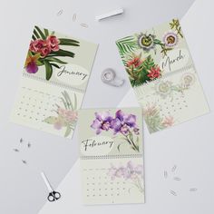 three calendars with flowers on them next to scissors