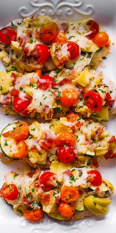 two slices of zucchini stuffed with tomatoes and other veggies on a white plate