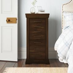 a bedroom scene with focus on the chest of drawers and the bed in the background