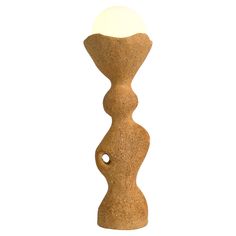 a small light sitting on top of a wooden stand next to a white ball in the middle