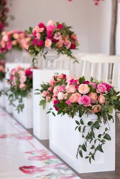 rows of white chairs with pink and red flowers on them