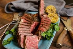 a blue plate topped with sliced up steak and garnished with cilantro