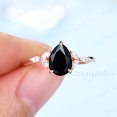 a woman's hand holding a black and white diamond ring