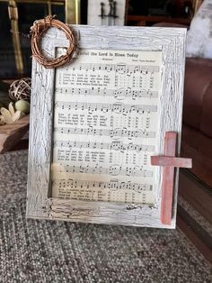 an old sheet music frame with a cross on the side and a wreath hanging from it