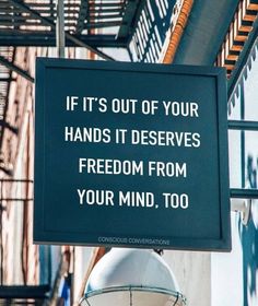 a sign hanging from the side of a building that says, if it's out of your hands it deserves freedom from your mind, too