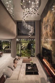 a living room with a couch, coffee table and chandelier hanging from the ceiling