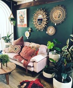 a living room filled with furniture and lots of plants on the wall next to it